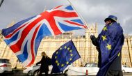 An anti-Brexit demonstrator waves a Union flag alongside a European Union flag outside the Houses of Parliament in London. (AFP / Tolga AKMEN)