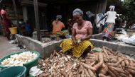 A woman peels outer layers of cassava (manioc) for the attieke side dish in Abidjan, on May 22, 2018.  AFP / Sia Kambou

