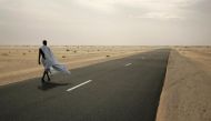 A man walks on the road where three Spanish aid workers were abducted from between Nouahibou and Nouakchott, Mauritania in a December 3, 2009 file photo. REUTERS/Rafael Marchante