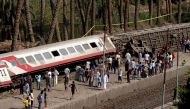Egyptians gather by the train tracks to look at the scene of a railway accident as a a train derailed near Badrasheen, a town some 20 kilometres (12 miles) from the Egyptian capital Cairo on July 13, 2018 leaving dozens injured. AFP