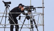 A police marksman awaits the arrival of US President Donald Trump on Air Force One at Prestwick Airport, south of Glasgow on July 13, 2018, on the second day of Trump's UK visit.  AFP / Andy Buchanan