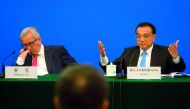 China's Premier Li Keqiang (R) gestures as he calls for action to problems raised by European businessmen, as European Commission President Jean-Claude Juncker (L) looks on, during the China-EU Business Roundtable at the Great Hall of the People in Beijin