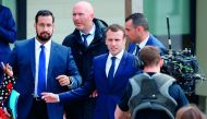 In this file photo taken on April 12, 2018 French President Emmanuel Macron (C), next to Elysee Chief Security Officer Alexandre Benalla (L), arrives at a primary school in Berd'huis, northwestern France, for a television interview in which he is expected