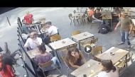 In surveillance video provided by the cafe, the man is then seen grabbing an ash tray from a table on the cafe's patio and throwing it at her.