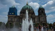 A man cools off in a fountain in front of the Berlin Cathedral as the heatwave in Europe continues with temperatures reaching 33 degrees Celsius in Berlin on August 4, 2018. (AFP / John MACDOUGALL)
