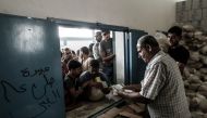 Palestinians receive aids at a United Nations food distribution centre in Jabalia refugee camp in the northern Gaza Strip on August 8, 2018. AFP / Mahmud Hams
 