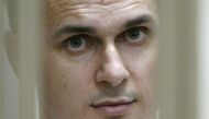 In this file photo taken on July 22, 2015 shows Ukrainian film director Oleg Sentsov looking on inside a defendants' cage during a hearing at a military court in the city of Rostov-on-Don. / AFP / SERGEI VENYAVSKY 
