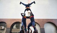 Acrobats perform outside the headquarters of Mali's incumbent president and candidate to his re-election in Bamako on August 13, 2018, in a show of support for the incumbent president one day after a presidential runoff vote. AFP / Michele Cattani
