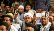People hold a picture of Iran's Supreme Leader Ayatollah Ali Khamenei, at the Hussayniyeh of Imam Khomeini in Tehran, Iran, August 13, 2018. Official Khamenei website/Handout via Reuters
