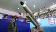 A handout picture released by Iran's Defence Ministry on August 13, 2018 shows Defence Minister, Brigadier General Amir Hatami, standing by the next generation short-range ballistic missile 