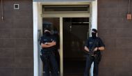 Catalan regional police (Mossos d'Esquadra) forces stand guard outside the apartment building of a man who tried to attack a police station in Cornella near the northeastern Spanish city of Barcelona on August 20, 2018.  / AFP / LLUIS GENE 