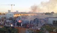 Smoke raise as people check the damaged after a rocket hit a camp for displaced people during the fight between rival armed groups in Tripoli, Libya September 2, 2018. Pictures taken September 2, 2018. REUTERS/Stringer 