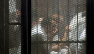 This picture shows detainees inside the soundproof glass dock of the courtroom during the trial of 700 defendants including Egyptian photojournalist Mahmoud Abu Zeid, widely known as Shawkan, in the capital Cairo, on September 8, 2018.  AFP / Mohamed el-S