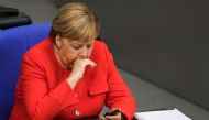German Chancellor Angela Merkel looks at her phone during a sitting of the Bundestag, Germany's lower house of parliament in Berlin on September 12, 2018. / AFP / Odd ANDERSEN