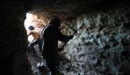 A man uses a pickaxe to dig a cave in the Syrian village of Kafr Ain in the southern countryside of the rebel-held Idlib province on September 15, 2018. AFP / OMAR HAJ KADOUR