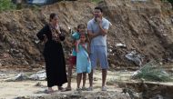 Tunisians look at the damage at the site of a collapsed bridge in the Tunisian coastal governorate of Nabeul on September 23, 2018 following deadly flash flooding in the town of Bir Challouf.  AFP / Fethi Belaid 