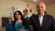 Barham Salih, Former Prime Minister of Iraq's Kurdistan Regional Government and Head of the Coalition for Democracy and Justice with his wife show their ink-stained fingers after casting their votes at a polling station during the parliamentary election i