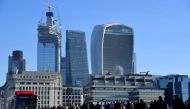 FILE PHOTO: Workers are seen crossing London Bridge with City of London skyscrapers seen behind during the morning rush hour in London, Britain, September 25, 2018. REUTERS/Toby Melville/File Photo