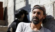 Abu Nimr, 36, is pictured with his dog in Yarmouk Palestinian camp in Damascus, Syria October 10, 2018. Picture taken October 10, 2018. REUTERS/Omar Sanadiki