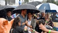 Britain's Prince Harry and his wife Meghan, Duchess of Sussex watch aboriginal dances at Victoria Park in Dubbo on October 17, 2018. / AFP / Pool / PETER PARKS