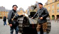 Two tank drivers pose with a Renault 17 tank on Place Ducale in Charleville-Mezieres, north-western France, on November 7, 2018, as French President Emmanuel Macron visits the Ardennes, a symbolic department of the Great War.   AFP / FRANCOIS NASCIMBENI
