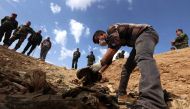 Members of the Yazidi minority search for clues that might lead them to missing relatives near the Iraqi village of Sinuni, in the northwestern Sinjar area In this file photo taken on February 03, 2015 . AFP / Safin Hamed
 
