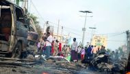  People gather at the scene of twin car bombs that exploded within moments of each other in the Somali capital Mogadishu on November 9, 2018.  AFP / Abdirazak Hussein Farah