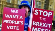 An anti-Brexit demonstrator holds placards outside the Houses of Parliament in London, Britain, November 13, 2018. Reuters/Toby Melville