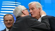 President of the European Commission Jean-Claude Juncker (C) kisses EU chief Brexit negotiator Michel Barnier (R) next to European Council President Donald Tusk (L) at the end of a press conference following a special meeting of the European Council to en
