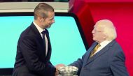 UEFA President Slovenian Aleksander Ceferin (L) shakes hands over the European Championship Trophy (C) with Irish President Michael D Higgins (R) during the UEFA Euro 2020 football competition qualifying draw in Dublin on December 2, 2018. AFP / Paul Fait