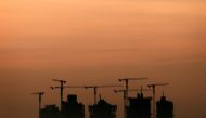 Cranes stand above an apartment complex under construction (Reuters/Tim Wimborne) 