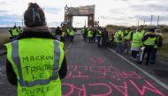 A Yellow vests (Gilets jaunes) protester with the words written of the back of her vest that read, ' Macron (referring to the French President) traitor, the people are hungry' blocks the road leading to the Frontignan oil depot in the south of France, as 