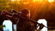 A Syrian Democratic Forces'(SDF) fighter holds a sniper rifle on his shoulder as he attends the funeral of a slain People's Protection Units (YPG) commander in the northeastern city of Qamishli on December 6, 2018. / AFP / Delil SOULEIMAN