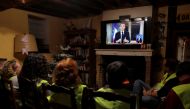 Protesters wearing yellow vests watch French President Emmanuel Macron who addresses the nation about the 