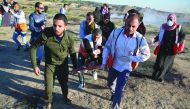 Health team members carry an injured Palestinian during Israeli intervention on the protest within the “Great March of Return” demonstrations at Al Bureij Refugee Camp in Gaza City, Gaza, yesterday.