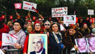 Members of Tunisia's Free Destourian Party (Free Constitutional Party) shout slogans and hold up protest signs and portraits of late president Habib Bourguiba as they demonstrate against the Truth and Dignity Commission (TDC) outside its closing conferenc