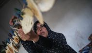  Gazan woman Fairouz attaches a bread on a rope with a clothespin in Gaza City, Gaza on December 12, 2018. ( Mustafa Hassona - Anadolu )	