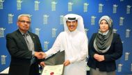 Dr Khalifa Nasser Al Khalifa (centre), CNA-Q President, receiving the  accreditations from Errol Persaud, P Eng, Education Consultant with CTAB, as Samah Gamar (right), Vice President-Academic CNA-Q, looks on at the CNAQ premises yesterday.  Pic: Abdul Ba