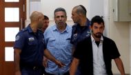 Gonen Segev, a former Israeli cabinet minister indicted on suspicion of spying for Iran, is escorted by prison guards as he arrives to court in Jerusalem, July 5, 2018. Reuters/Ronen Zvulun