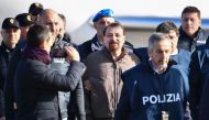 Italian former communist militant Cesare Battisti (C), wanted in Rome for four murders attributed to a far-left group in the 1970s, is escorted by Italian Police officers after stepping off a plane coming from Bolivia and chartered by Italian authorities,