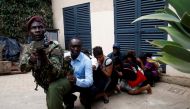 People are evacuated by a member of security forces at the scene where explosions and gunshots were heard at the Dusit hotel compound, in Nairobi, Kenya January 15, 2019. REUTERS/Baz Ratner