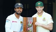 Sri Lanka's captain Dinesh Chandimal (L) and Australia's captain Tim Paine pose with the Warne-Murali Test trophy at The Gabba in Brisbane on January 23, 2019, ahead of their first day-night Test match between Australia and Sri Lanka on January 24. AFP / 