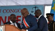Democratic Republic of the Congo's newly inaugurated President Felix Tshisekedi is assisted by an aide on January 24, 2019 after he fell ill while delivering his official speech that followed his inauguration at the Presidency in Kinshasa.   AFP / TONY KA