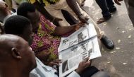 Nigerians read a daily newspaper on February 16, 2016 in Lagos after the national election has been postponed.   AFP / STEFAN HEUNIS