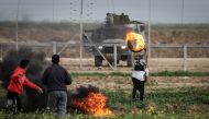 Palestinians burn tyres as Israeli forces intervene them during the 