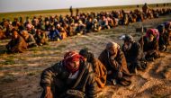 Men suspected of being Islamic State (IS) fightrs wait to be searched by members of the Kurdish-led Syrian Democratic Forces (SDF) after leaving the IS group's last holdout of Baghouz in Syria's northern Deir Ezzor province, on February 22, 2019. / AFP / 