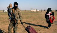 A fighter from Syrian Democratic Forces (SDF) holds a baby near the village of Baghouz, Deir Al Zor province, Syria March 1, 2019. REUTERS/Rodi Said 