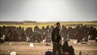 Civilians who streamed out of the Islamic State group's last Syrian stronghold sit at a screening point for new arrivals run by US-backed Syrian Democratic Forces outside Baghouz in the eastern Syrian Deir Ezzor province on March 5, 2019. AFP / Delil SOUL