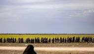 Men suspected of being Islamic State (IS) group fighters walk together towards a screening point for new arrivals run by US-backed Syrian Democratic Forces, where suspected jihadists -- many of them wounded -- were being interrogated outside Baghouz in th