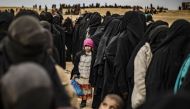 Women and children queue at a screening point as hundreds of civilians, who streamed out of the Islamic State group's last Syrian stronghold, arrive in an area run by US-backed Syrian Democratic Forces outside Baghouz in the eastern Syrian Deir Ezzor prov